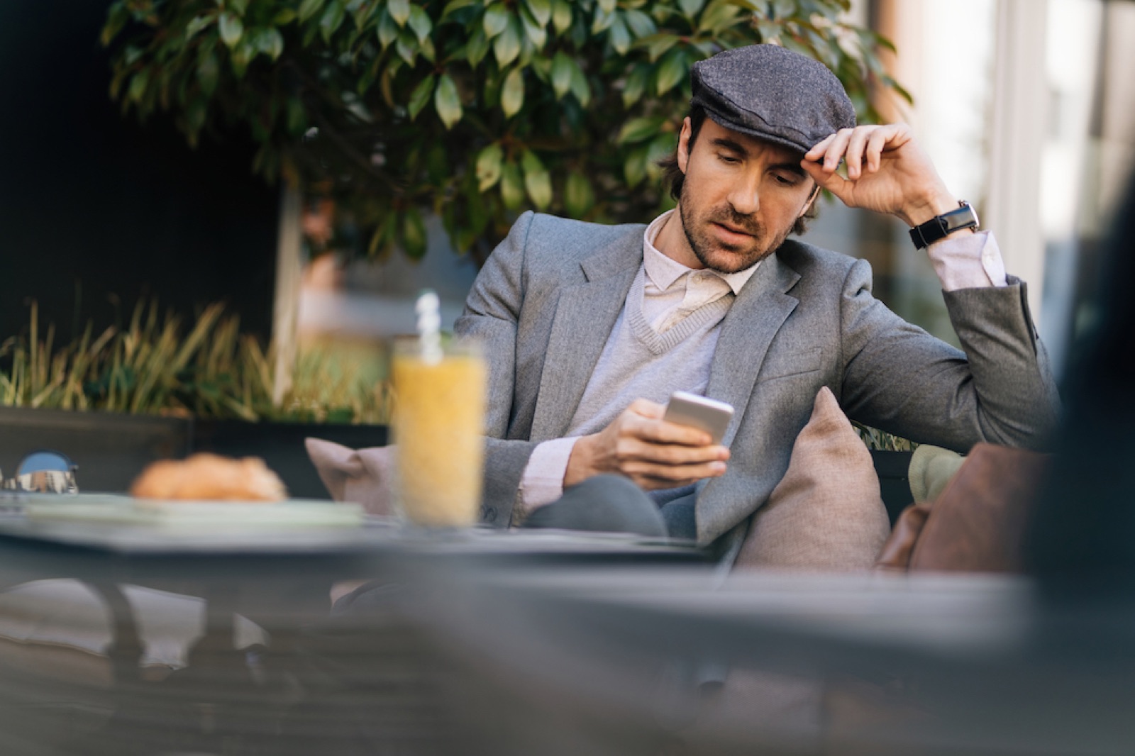 A young landlord reading a message on their phone at a cafe